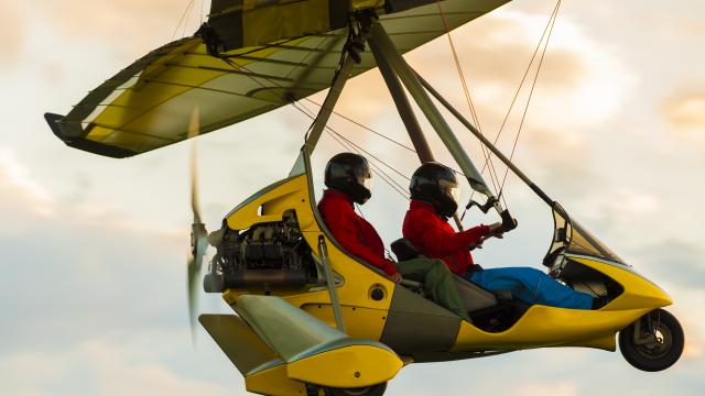 Microlight aircraft in the air flying in sunset