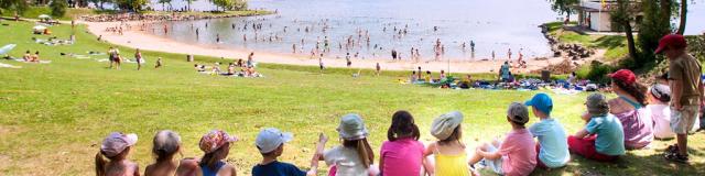 Enfants assis au bord du lac de la base de loisirs de Léry-Poses en Normandie