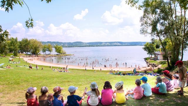 Enfants assis au bord du lac de la base de loisirs de Léry-Poses en Normandie