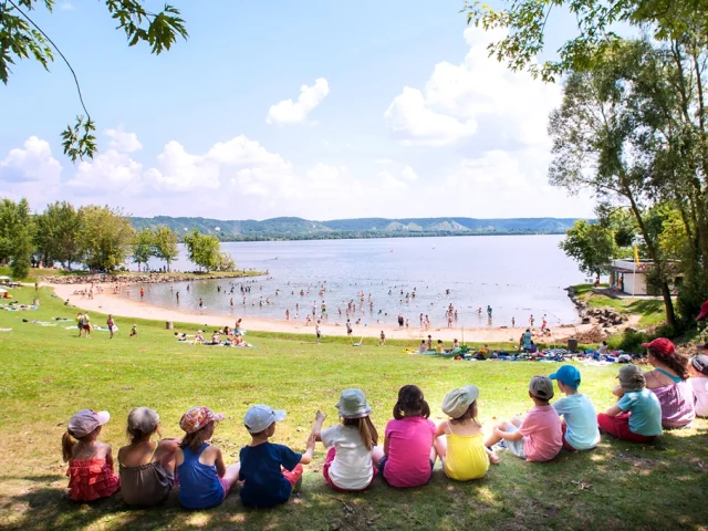 Enfants assis au bord du lac de la base de loisirs de Léry-Poses en Normandie