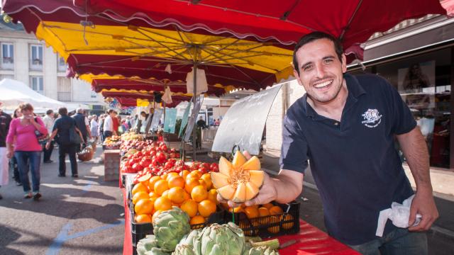 Vue d'un producteur local souriant présentant ses melons au marché de Louviers en Normandie