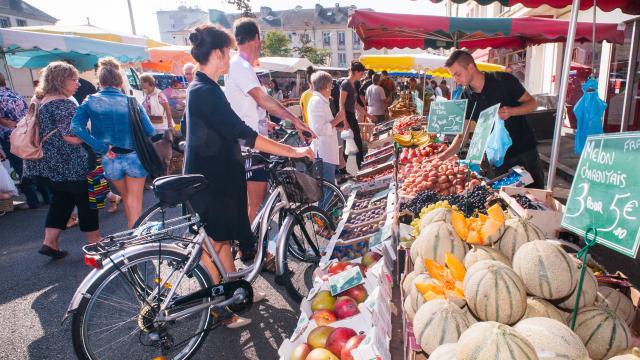 clients à vélo achetant leurs fruits et légumes au marché de Louviers en Normandie