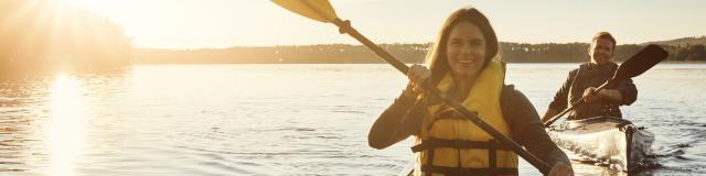 Shot of a young couple kayaking on a lake outdoors