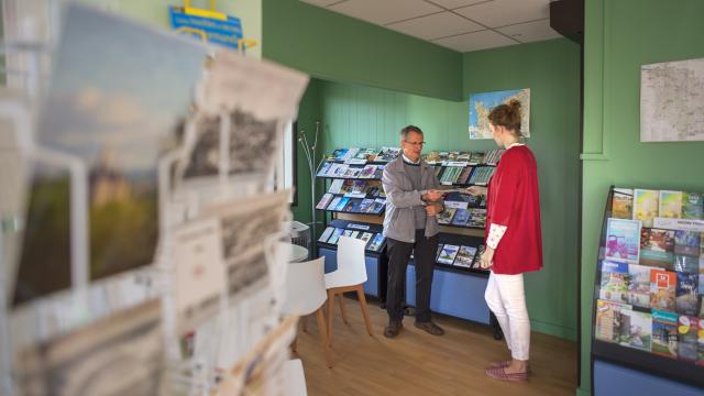 Conseillère de l'office de tourisme de Gaillon en train de renseigner un touriste en lui présentant un document