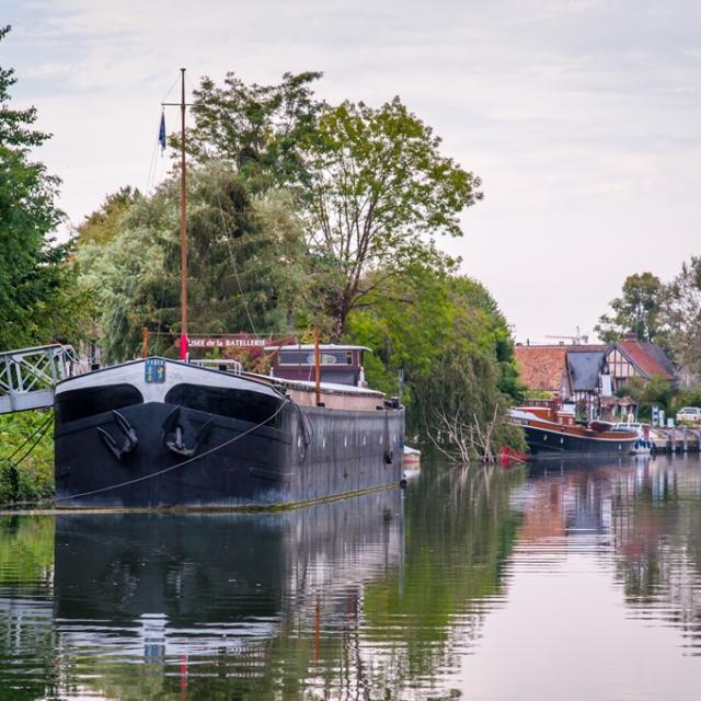 photo des bords de seine en campagne normandes avec ses anciens bateaux amarrés