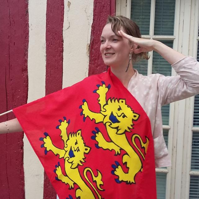 Photo de Célia, agent d'accueille à l'office de tourisme de Seine-Eure avec son drapeau de la Normandie