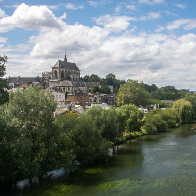 Vue du village de Pont-de-l'Arche en Normandie sous ciel bleu avec la rivière de l'Eure en premier plan