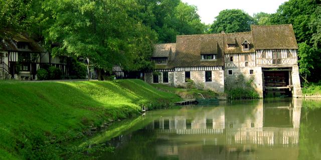 Le moulin d'Andé dans son écrin de verdure en bord de Seine