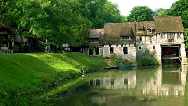 Le moulin d'Andé dans son écrin de verdure en bord de Seine