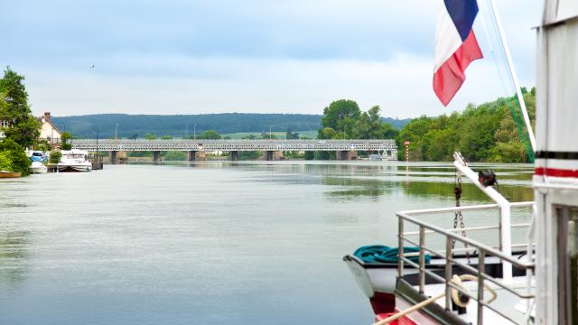 photo d'une écluse de la seine vue depuis un bateau blanc avec drapeau français