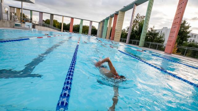 homme nageant le crawl dans le bassin extérieur de la piscine Caseo en Normandie