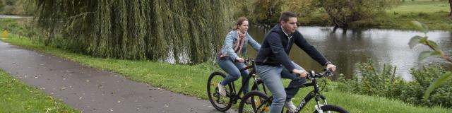 couple faisant du vélo par temps bleu sur la voie verte le long de la rivière de l'Eure en Normandie