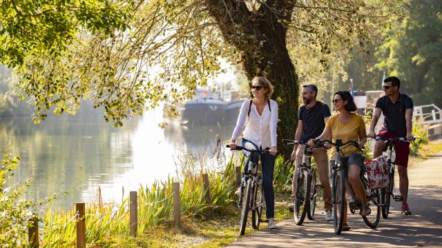 photo de 4 personnes se promenant à vélo sur la piste cyclable en bord de Seine à Poses dans l'Eure en Normandie