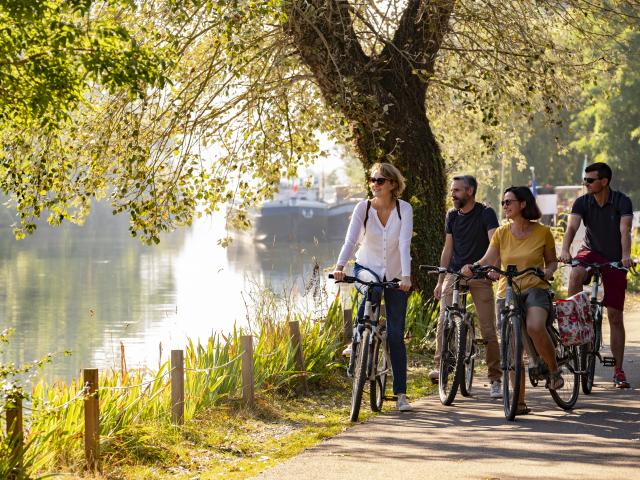 photo de 4 personnes se promenant à vélo sur la piste cyclable en bord de Seine à Poses dans l'Eure en Normandie